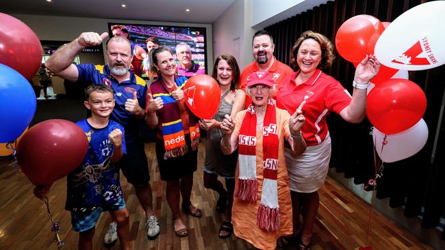 Waxen McLennan, 9, Morag Meikle and Amber Cassidy cheer on the Lions, and Lisa Creswell, Judy Daly, Tim Gregory and Belinda Green cheer on the Swans while watching the 2024 AFL grand final match between the Brisbane Lions and the Sydney Swans at Cazalys Sports Club, Cairns. Picture: Brendan Radke