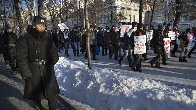 Police guard as Russian gay rights activists march along a Moscow boulevard during a rally, in downtown on Sunday, January 19, 2014.