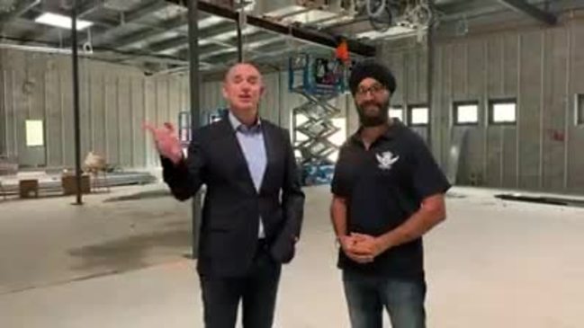 Fadden MP Stuart Robert presents Gold Coast Sikh Council general manager Surjit Singh with a cheque