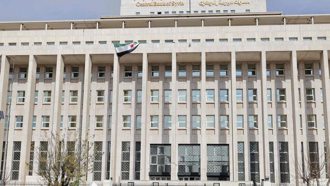 Vehicles move past the main headquarters of the Central Bank of Syria. Picture; AFP.