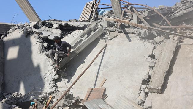 A Palestinian man climbs down on the debris of a building after an Israeli strike in the Shejaiya suburb east of Gaza City on September 12. Picture: AFP