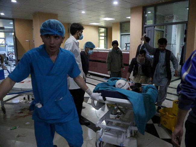 An injured man is being brought on a stretcher to a hospital following a blast outside a school in the west Kabul district of Dasht-e-Barchi on May 8, 2021, that killed at least 25 people and wounded scores more including students, officials said. (Photo by ZAKERIA HASHIMI / AFP)