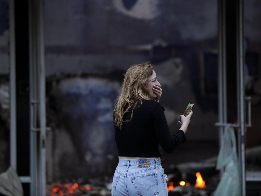 A woman cries as she watches a building burn after a protest over the death of George Floyd in La Mesa, Calif. Picture: Gregory Bull