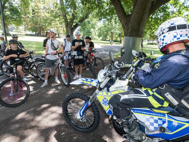 Police keep watch on the riders at Flagstaff Gardens. Picture: Tony Gough