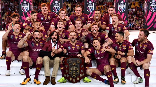 Maroons players celebrate with the State of Origin shield.