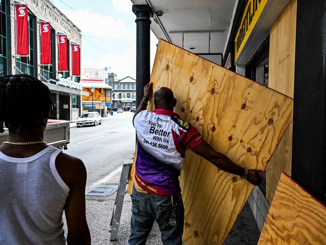 A man prepares to board up a shop window as people prepare for the arrival of Hurricane Beryl in Bridgetown, Barbados. (Photo by CHANDAN KHANNA / AFP)