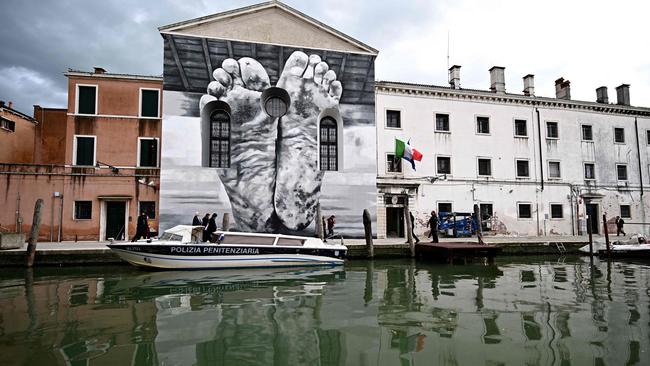 A mural by artist Maurizio Cattelan is displayed outside Giudecca Women’s Prison, which hosts the Holy See pavilion at the pre-opening of the 60th Venice Biennale. Picture: Gabriel Bouys/AFP