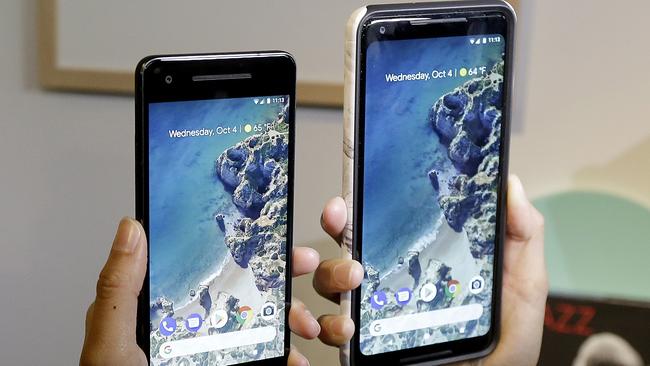 A woman holds up the Google Pixel 2 phone, left, next to the Pixel 2 XL phone at a Google event at the SFJAZZ Center in San Francisco. Picture: AP Photo/Jeff Chiu