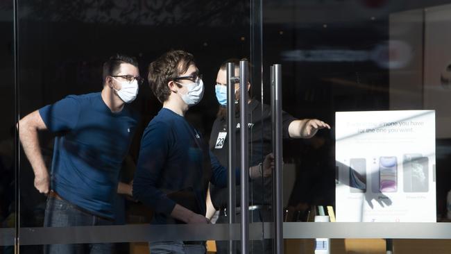 Apple staff and security wearing protective gear as they prepare the store for reopening in Rundle Mall after being closed due to COVID-19. Picture: Emma Brasier