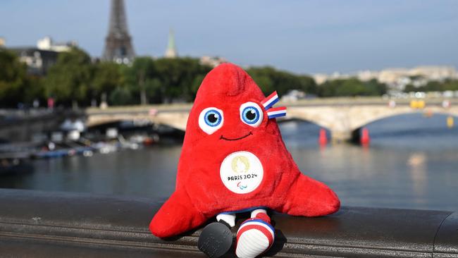 The Paris 2024 Olympics mascot, the Phrygian cap, symbol of revolutions, the French Republic and freedom, is placed on the railings of the Alexander III Bridge that crosses the River Seine, during the swim familiarisation event on the eve of a planned triathlon test races in Paris, on August 16, 2023. From August 17 to 20, 2023, Paris 2024 is organising four triathlon events to test several arrangements, such as the sports operations, one year before the Paris 2024 Olympic and Paralympic Games. (Photo by Bertrand GUAY / AFP)