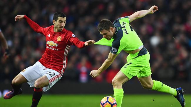 Henrikh Mkhitaryan (L) of Manchester United pulls the shirt of Liverpool’s James Milner.