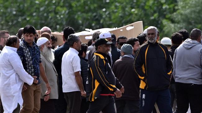 Mourners carry the first coffin of the Christchurch mosques massacre victim at Memorial Park Cemetery during this morning’s funeral ceremony. Picture: Anthony Wallace/AFP