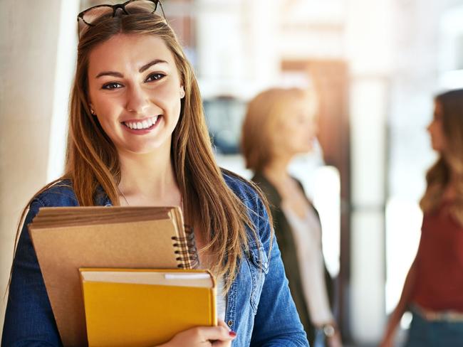 CAREERS FOR MARCH 30 EXPO COVER: Portrait of a smiling female university student standing on campus with friends in the background