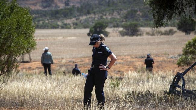 Major Crime detectives, police officers and STAR Group officers search in grass and bush along Peak Rd, between Peterborough and Orroroo. Picture: Emma Brasier