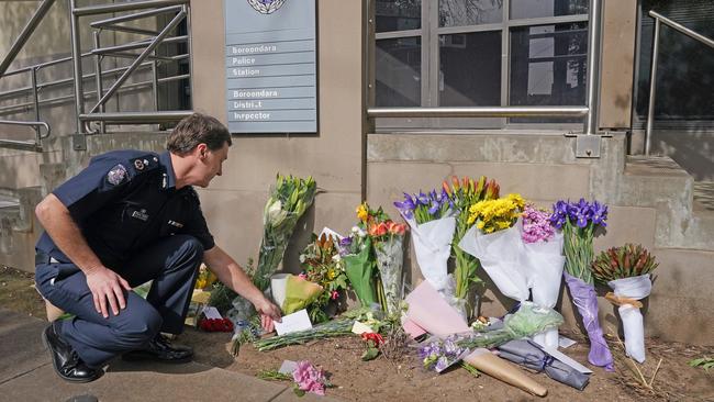 Deputy Commissioner Shane Patton lays a tribute at Boroondara police station, near the Chandler Highway in Kew. Picture: AAP