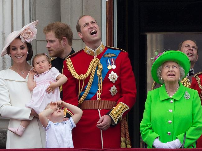 (L-R) Britain's Catherine, Duchess of Cambridge holding her daughter Princess Charlotte, Prince George, Britain's Prince William, Duke of Cambridge, Britain's Queen Elizabeth II and Prince Philip, Duke of Edinburgh stand on the balcony of Buckingham Palace to watch a fly-past of aircrafts by the Royal Air Force, in London on June 11, 2016.  Trooping The Colour and the fly-past are part of a weekend of events to celebrate the Queen's 90th birthday. / AFP PHOTO / JUSTIN TALLIS