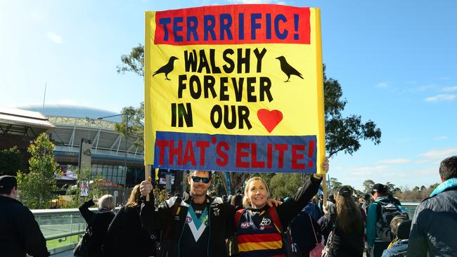 Port Adelaide and Crows fans march from Rundle Mall to the Adelaide Oval for Showdown. Daniel Walton and Sue Thalbourne with their sign for Phil Walsh. Picture: Mark Brake