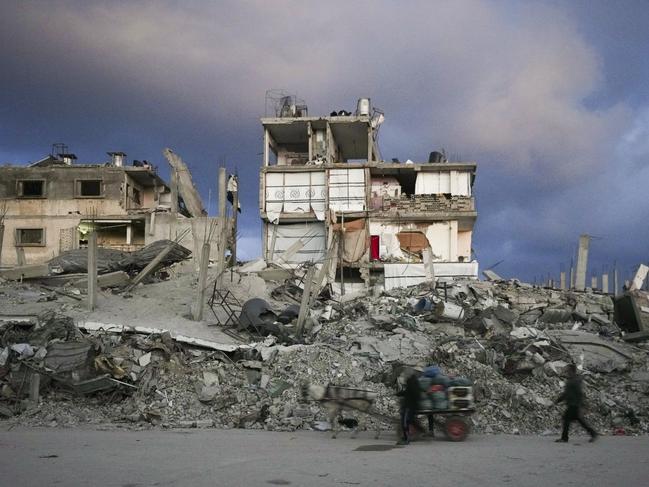 A man pushes a cart past a house that remains partly standing in the Gaza Strip, in an area largely destroyed by the Israeli army's air and ground offensive. Picture: AP