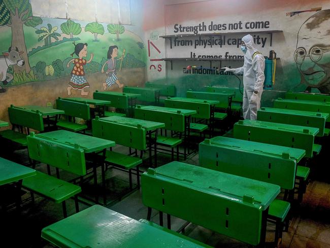 A worker sprays disinfectant inside a classroom ahead of the reopening of schools closed as a preventive measure to curb the spread of the Covid-19 coronavirus, in Mumbai India. Picture: AFP