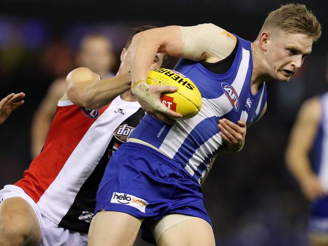 North Melbourne's Jack Ziebell tries to charge through the tackle.
