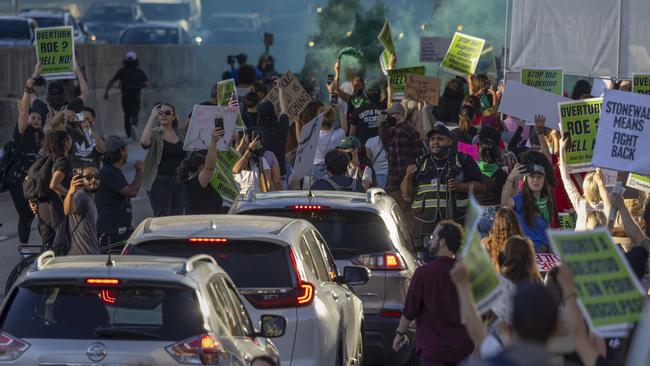 Smoke rises as protesters march on a freeway in Los Angeles. Picture: David McNew/Getty Images/AFP