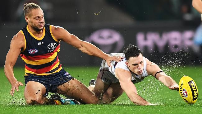 Cam Ellis-Yoleman and Toby McLean slide to the ball in the wet at Adelaide Oval on Friday night.