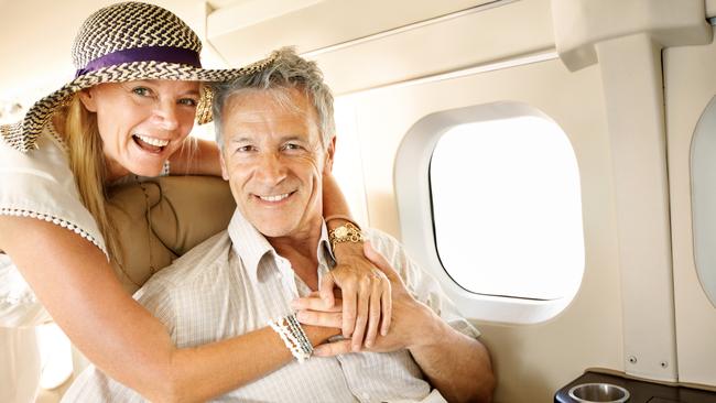 Smiling senior couple on an airplane heading overseas - portrait