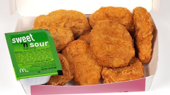 ONE TIME WEB USE FOR NEWS.COM.AU ONLY - FEES APPLY - MUST DOWNLOAD ON OWN ACCOUNT - CF8E07 McDonald's chicken mcnuggets in box packaging and sweet and sour dipping sauce with lid open on white background cut out USA. Picture: Alamy