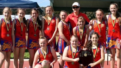 Sarah Locke (pictured with hat) with the premiership winning Seymour Football Netball Club under-12 team. Picture: Supplied.