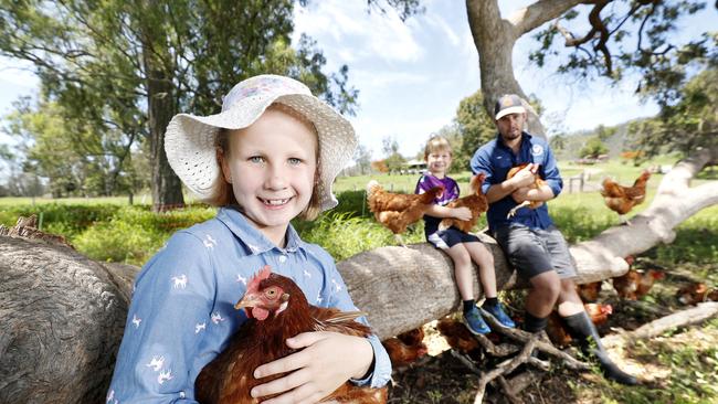 Juliette Martens, 8, and Atticus Martens, 5, with Tom Hall from The Tommerup Dairy Farm south of Beaudesert. Picture: Josh Woning