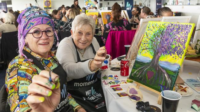 Trish Hedge (left) and Jan Rollo participate in the World's Largest Paint and Sip Luncheon for Momentum Mental Health at Clifford Park racecourse, Friday, June 21, 2024. Picture: Kevin Farmer