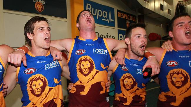 Jonathan Brown celebrates a win with teammates Jed Adcock, Andrew Raines and Tom Rockliff during the 2012 season.