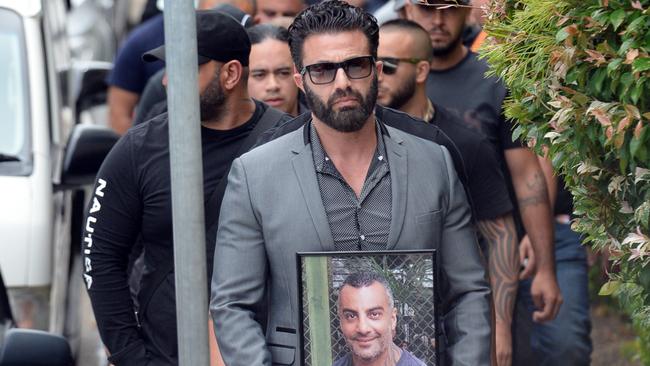 A man carries a portrait of Mick Hawi. Picture: Jeremy Piper.