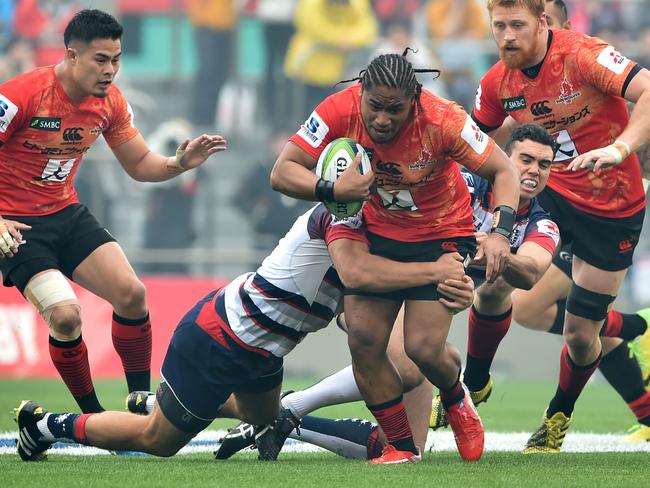 Sunwolves WTB Mifiposeti Paea (C) is tackled by Rebels players CTB Mitch Inman (2nd L) and SO Jack Debreczeni (2nd R) during the round-four Super Rugby league match between Japan Sunwolves and Rebels from Australia at the Prince Chichibu Memorial Rugby Ground in Tokyo on March 19, 2016. / AFP PHOTO / KAZUHIRO NOGI