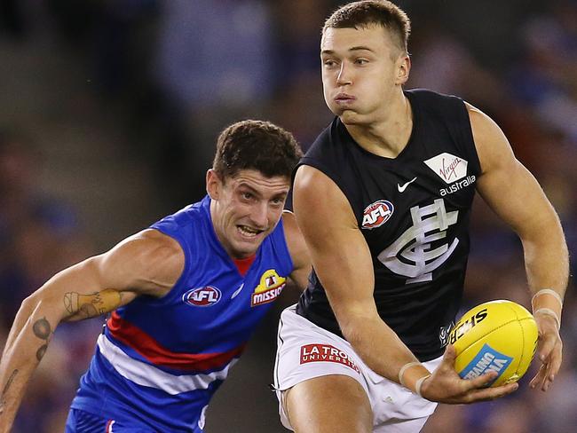 AFL Round 5. 21/04/2019. Western Bulldogs v Carlton at Marvel Stadium.  Patrick Cripps of the Blues clears infant of Bulldog Tom Liberatore  1st quarter     . Pic: Michael Klein.