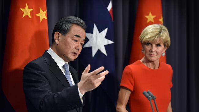 Red right hand: Chinese Foreign Minister Wang Yi tells Julie Bishop his mad kung fu skills could split a stack of White Papers. Picture: AFP