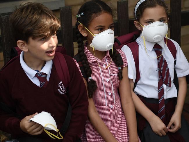 Young children wear masks to protect themselves from clouds of ash and soot that fell on Wednesday. Picture: Carl Court/Getty Images