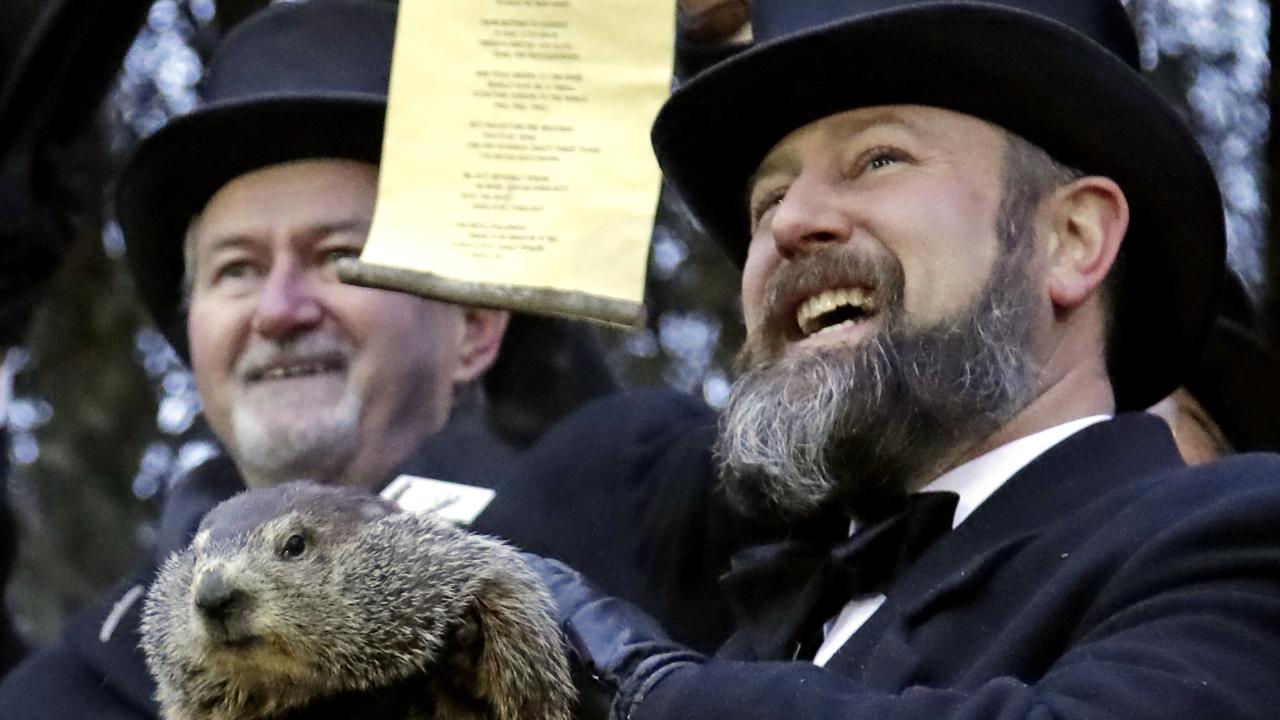 Groundhog Club co-handler Al Dereume, right, holds Punxsutawney Phil, the weather prognosticating groundhog, during the 133rd celebration of Groundhog Day on Gobbler's Knob in Punxsutawney. Picture: AP