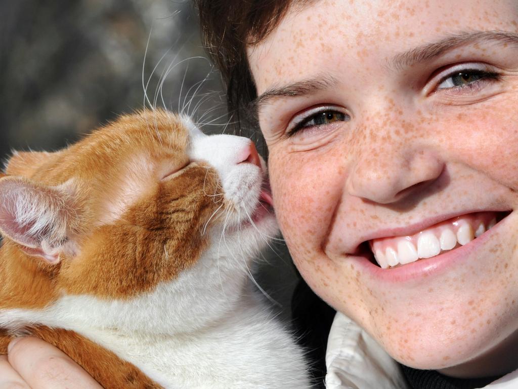 SMART PETS. happy freckled girl and funny red cat outdoors. Picture: iStock