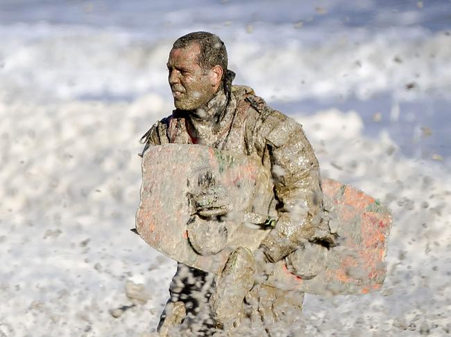 A rescue worker stands in rough waters during the resumed search for missing water sports participants in The North Sea at Scheveningen, The Netherlands on May 12, 2020. - The coastguard, police, fire brigade and KNRM are looking for potentially an additional three missing persons after May 11, when two surfers who were taken out of the sea have died. (Photo by Sem VAN DER WAL / ANP / AFP) / Netherlands OUT