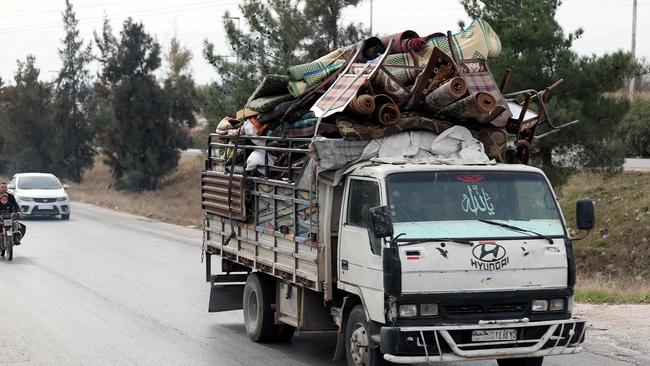 People ride a vehicle loaded with belongings in Syria's Hama governorate after anti-government forces took control of the area. Picture: AFP