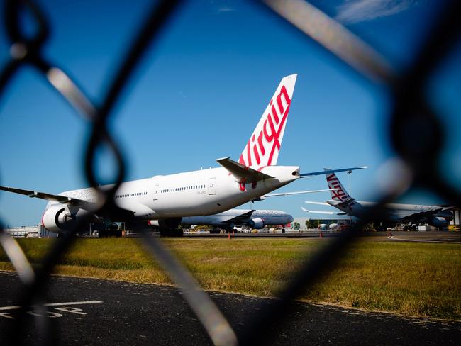 Virgin Australia aircraft are seen parked on the tarmac at Brisbane International airport on April 21, 2020. - Cash-strapped Virgin Australia collapsed on April 21, making it the largest carrier yet to buckle under the strain of the coronavirus pandemic, which has ravaged the global airline industry. (Photo by Patrick HAMILTON / AFP)