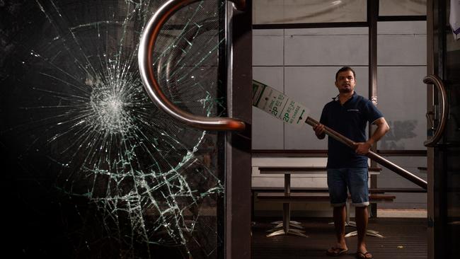 Outback Steaks &amp; Curry has been hit again by thieves, the second break-in in a matter of days. Co-owner Deepak Sharma stands with the street sign the alleged offenders used to smash the windows. Picture: Che Chorley