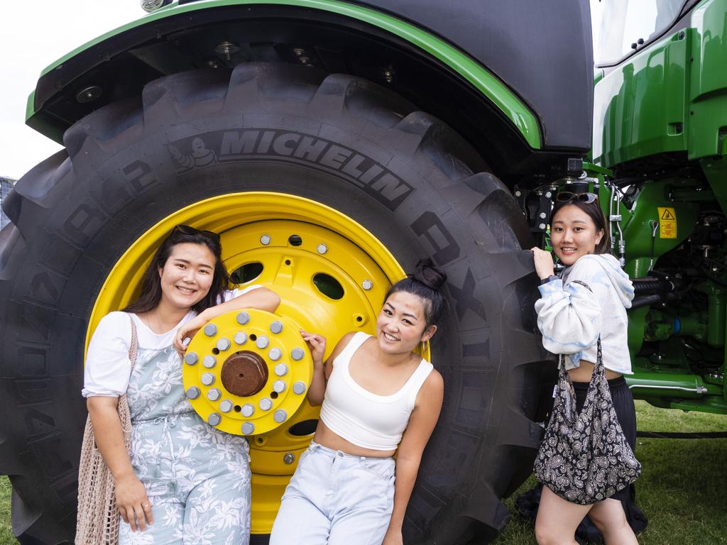 USQ students (from left) Mihwa Jeon, Minseo Jung and Hyunsu Kim with a tractor at the 2022 Toowoomba Royal Show, Friday, March 25, 2022. Picture: Kevin Farmer