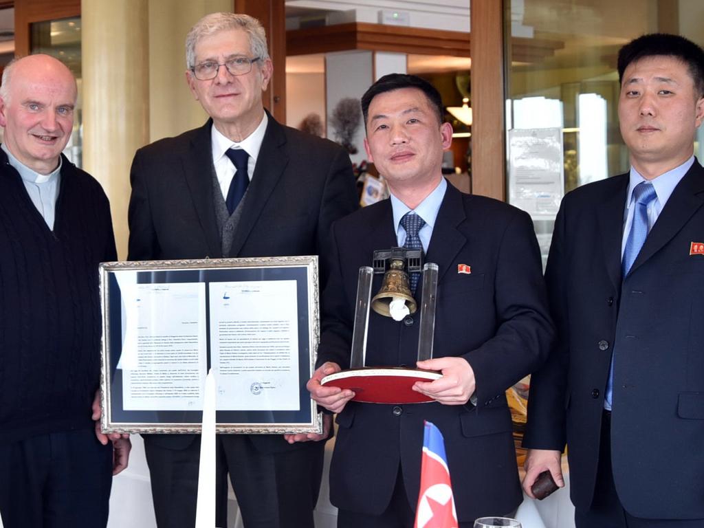 Korea's acting ambassador to Italy Jo Song Gil, second from right, holding a model of "Bell of Peace of Rovereto" during a cultural event on the occasion of a visit of the North Korean delegation to the Veneto region, in northern Italy. Picture: AP