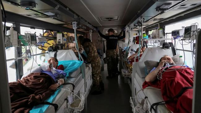 Volunteers of the Ukrainian volunteer paramedic organisation Hospitallers support a Ukrainian serviceman who was injured in Bakhmut. Picture: Reuters