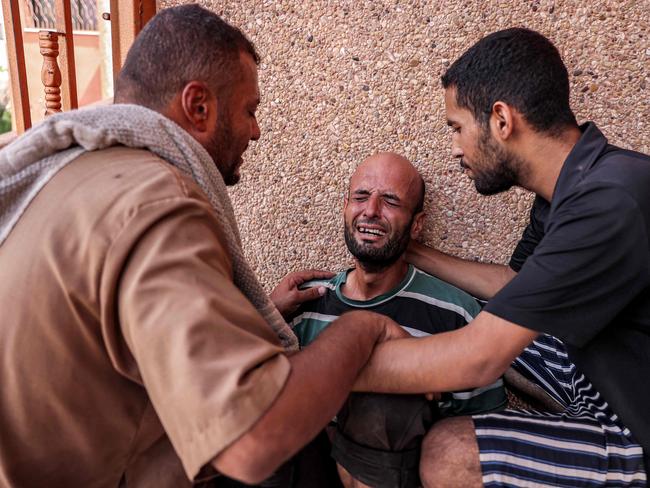 A man is comforted as he mourns his son who was killed in Israeli bombardment on a bakery, at Nasser Medical Complex in Khan Yunis in the southern Gaza Strip. Picture: AFP