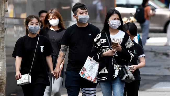 People are seen wearing face masks in Sydney on Monday. Picture: AAP