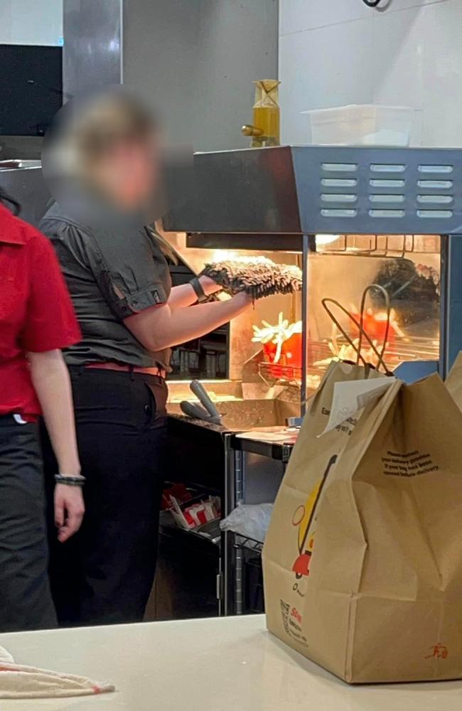 The McDonald’s worker drying a broom under a heat lamp in the fry station. Picture: Facebook