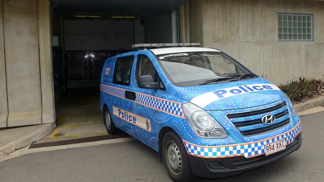 A police vehicle delivers a man into the Townsville watchhouse.